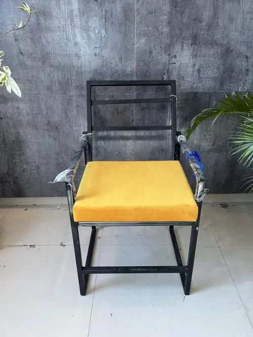 iron chair in black with yellow cushion