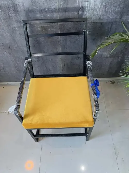black iron chair with yellow cushion